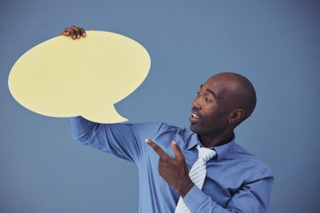 Homem segurando balão de fala para publicidade ou marketing contra um fundo azul