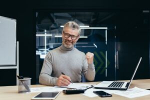 Empresas de contabilidade: Imagem de contador sorrindo usando o notebook