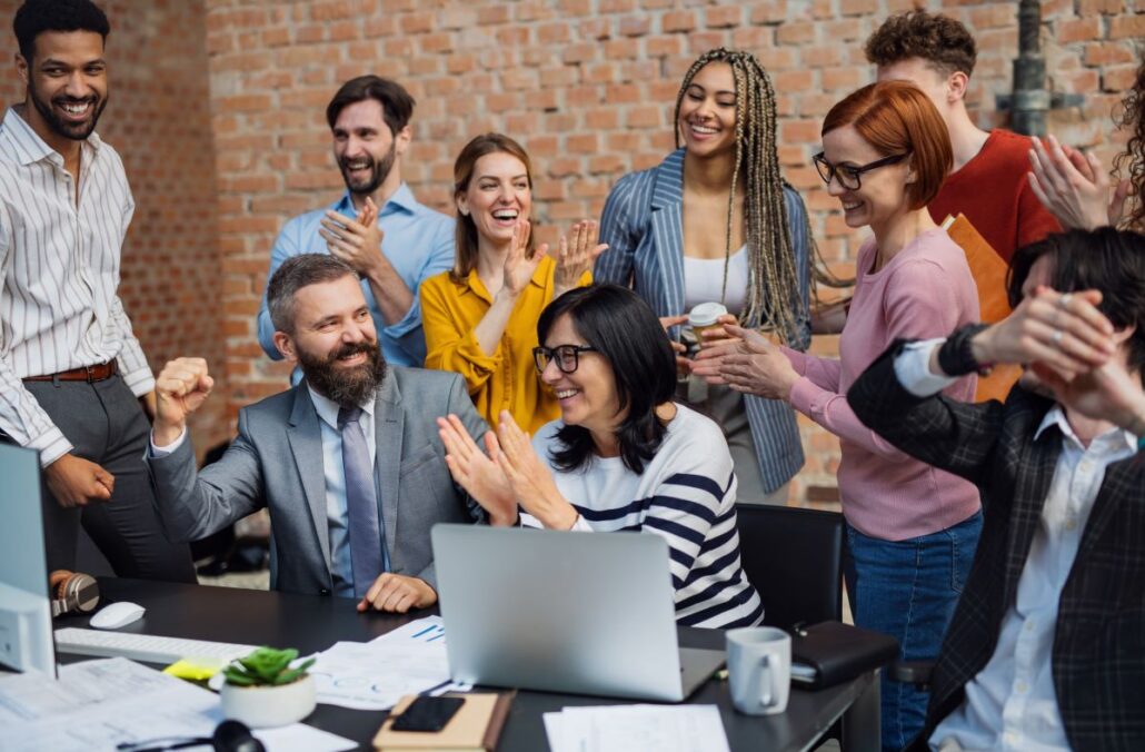Táticas de presença digital - Equipe trabalhando em projetos no escritório, celebrando um contrato bem-sucedido.
