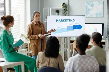 Estratégias de E-mail Marketing - Mulher apresentando estratégia de marketing para colegas
