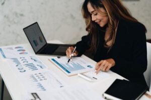 Backlinks cuidando dos links - Jovem analisando dados e gráficos ao lado do notebook