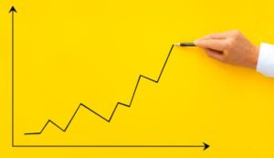 Trafego pago - Mão de empresario desenhando um grafico mostrando o cresimento dos negócios