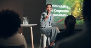 ESG na contabilidade - Contadora discursando em palestra sobre ideias sustentáveis e decisões corporativas responsáveis